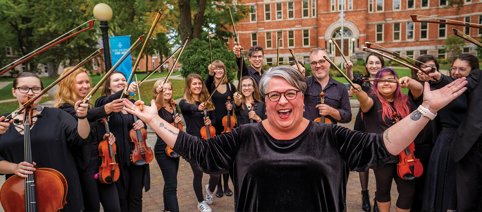 Orchestra professor looking excited in a group of student musicians